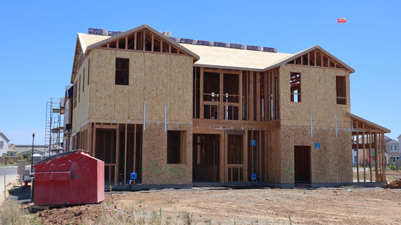 Modern house under construction in Elk Grove, CA, showcasing wooden framing.